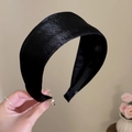 Detailed view of wide black satin headband with smooth silk texture and elegant finish - Black