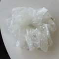 Détail d'un chouchou en tulle blanc à pois avec une texture plissée douce et élégante - Blanc Cassé