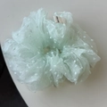Dettaglio dello scrunchie in organza verde menta a pois con etichetta tessuta Hand Made - Verde