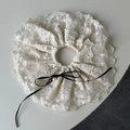 Detailed close-up of cream lace scrunchie with embroidery and pearl bow accent - Off-white