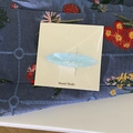 Vista de primer plano de la pinza ovalada azul claro con diseño de nácar en tarjeta - Azul