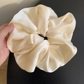 Detail view of a large champagne satin hair scrunchie with smooth pleated silk texture - Large / Off-white