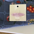 Dettaglio del fermaglio ovale rosa effetto conchiglia su cartoncino di supporto - Viola