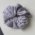 Detailed close-up of a large lavender scrunchie with black heart patterns and fabric label - Purple