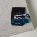 Close-up of retro acetate wave hair clips with marble texture and cut-out logo detail - Blue Series