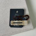 Close-up of retro acetate wave and scallop hair clips on a branded display card - Brown Series