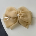 Detail showing the light yellow gingham tulle fabric and bow texture of the hair clip - Yellow