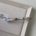 Macro detail of marble pattern acetate hair clip with golden Barrette La France lettering - Blue Apricot