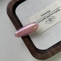 Dettaglio ravvicinato di un fermaglio per capelli rosa in acetato con lettera dorata - Rosa