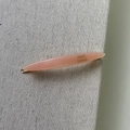 Close-up of peach acetate hair clip with gold-tone base and France Handmade text - Light Orange