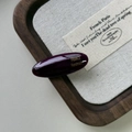 Dettaglio di un fermaglio per capelli in acetato viola scuro con logo dorato su lino - Rosso Porpora Scuro