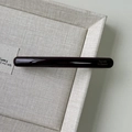 Detailed close-up of slim dark brown acetate hair clip with gold lettering on tray - Dark Coffee