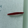 Detailed macro view of red willow leaf acetate hair clip with gold handmade lettering - Red