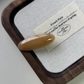 Dettaglio di un fermaglio per capelli in acetato ambrato con scritta dorata fatta a mano - Cachi