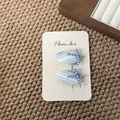 Detail of light blue floral fabric bow hair clips on a cream display card - Fat Teardrop Bow Style