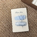 Dettaglio di fermagli per capelli in tessuto azzurro e a righe su carta premium - Stile Bruco