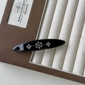 Dettaglio ravvicinato di un fermaglio per capelli ovale nero vintage con motivi di strass - Nero