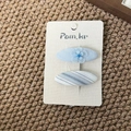 Detail view of light blue fabric hair clips with floral mesh and striped patterns on card - Floral Oval Style