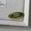 Dettaglio del fermaglio ovale verde avocado con incisione dorata Barrette La France - Verde