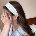 Detail of white ribbed headband with silver heart charm on model in soft profile view - Off White
