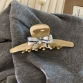 Dettaglio del fermaglio per capelli in acetato color tè al latte con fiocco marmorizzato - Cachi