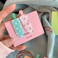 Dettaglio di set mollette per capelli floreali in verde menta e rosa su carta - Fermagli Floreali