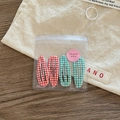 Close-up of 4-piece red and green plaid BB hair clips in gift packaging with sticker - Red and Green Gingham Mix