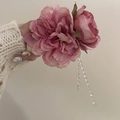 Dettaglio del fermaglio per capelli con peonia, rosa e lunghe nappe di perline in mano - Rosa