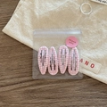 Detailed view of four pink plaid checkered hair clips in transparent gift packaging - Pink Plaid