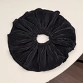 Detailed macro view of black pleated fabric scrunchie with neat stitched edges - Black