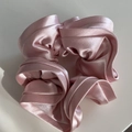 Primer plano de coletero de satén rosa claro con textura sedosa y pliegues voluminosos - Rosa
