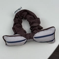 Detailed view of a dark brown scrunchie with striped bow and handmade label - Blue Striped Bow Scrunchie