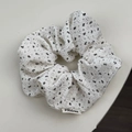 Detail van grote witte bloemen scrunchie met getextureerde stof en merklabel - Groot Rijstwit