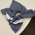 Detailed macro view of the blue gingham fabric headband with lace trim and ribbon bow - Small Plaid Streamer Style