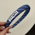 Détail d'un serre-tête en tissu bleu marine à rayures avec un écusson hello blanc - Serre-tête Rayé