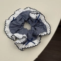 Macro view of blue plaid hair scrunchie with white lace edges and small bows decoration - Fine Plaid Style