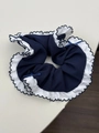 Close-up of navy blue scrunchie with white ruffled edges and small decorative silk bows - Navy Blue Style