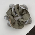 Olive green and striped pleated fabric scrunchie with a brown decorative tag detail - Green Patchwork Stripes