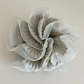 Detail van grijze geplooide stof en witte organza ruches op de grote scrunchie - Groen