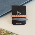 Détail de barrettes colorées en acétate orange et bleu sur une carte noire - Clips Vague Et Ovale / Carreaux Patchwork Rose Bleu