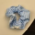 Détail du chouchou en satin à carreaux bleus avec dentelle et étiquette de marque - Chouchou Plaid Bleu