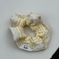 Detail eines gelb gestreiften Haargummis mit Spitzenbesatz und dekorativem Knopf - Haargummi / Gelbes Gingham Haargummi