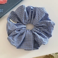 Dettaglio di elastico per capelli a quadretti blu con etichetta su sfondo bianco - Plaid Blu Scuro