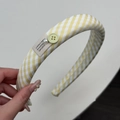 Gros plan détaillé du chouchou à carreaux jaunes avec bouton et perles décoratives - Serre-tête Gingham jaune