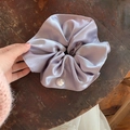 Dettaglio di un elastico per capelli in raso lavanda con perla su un tavolo in legno retrò - Viola