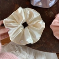 Dettaglio di eleganti elastici scrunchie in raso con perle bianche su legno vintage - Bianco Sporco