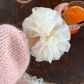 Close-up of fluffy white layered lace mesh scrunchie worn on wrist for balletcore style - Off-white