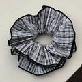 Close-up of black and white checkered scrunchie with lace trim and soft pleats - Black