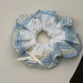 Dettaglio ravvicinato dell'elastico per capelli a righe blu con pizzo e fiocco - Elastico Blu con Fiocco