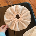 Détail d'un chouchou géant en mousseline rose pâle avec texture jacquard à motifs floraux - Blanc Cassé